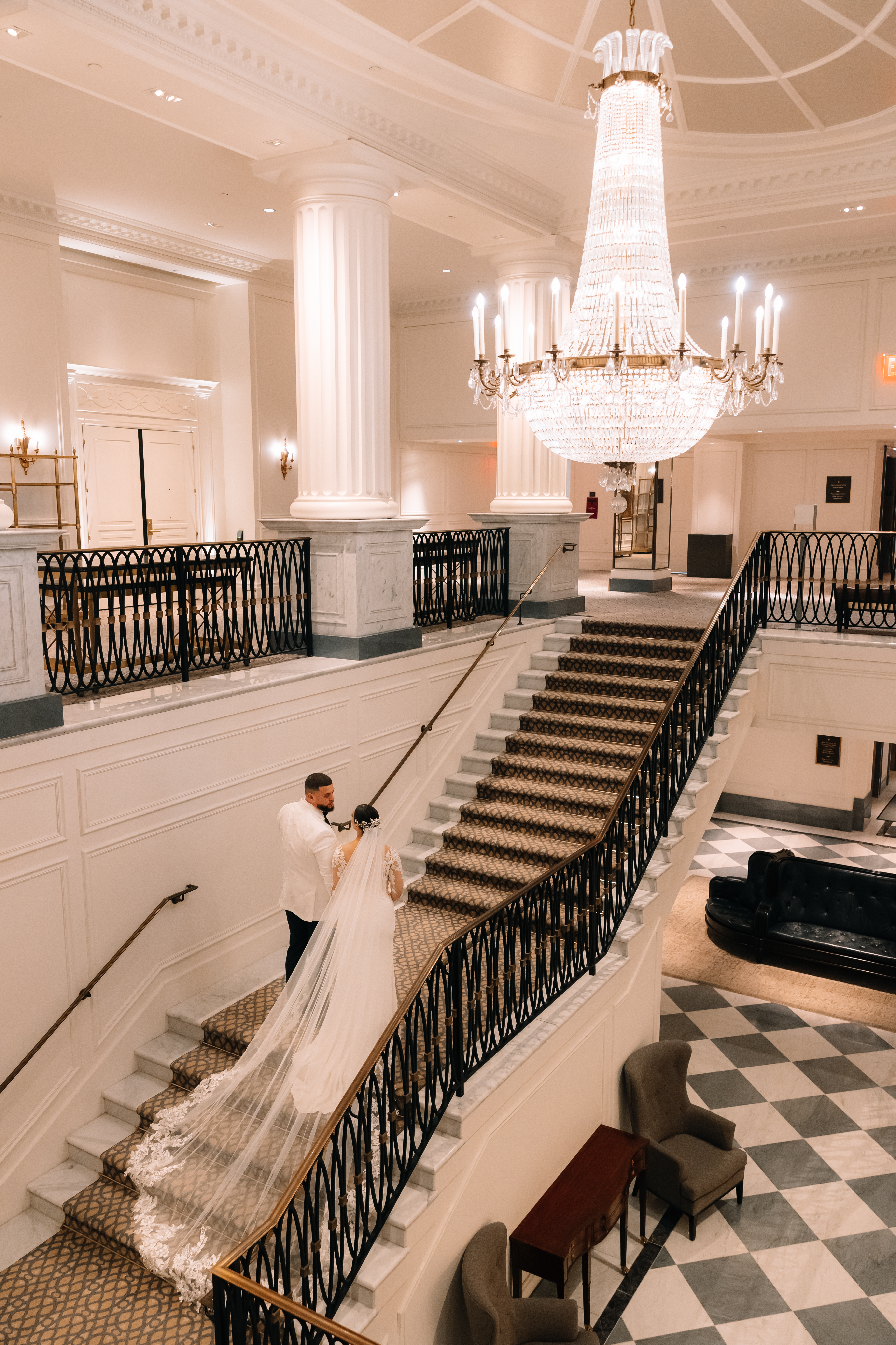 Bride and Groom walking down an elegant staircase inside a grand venue at InterContinental New York